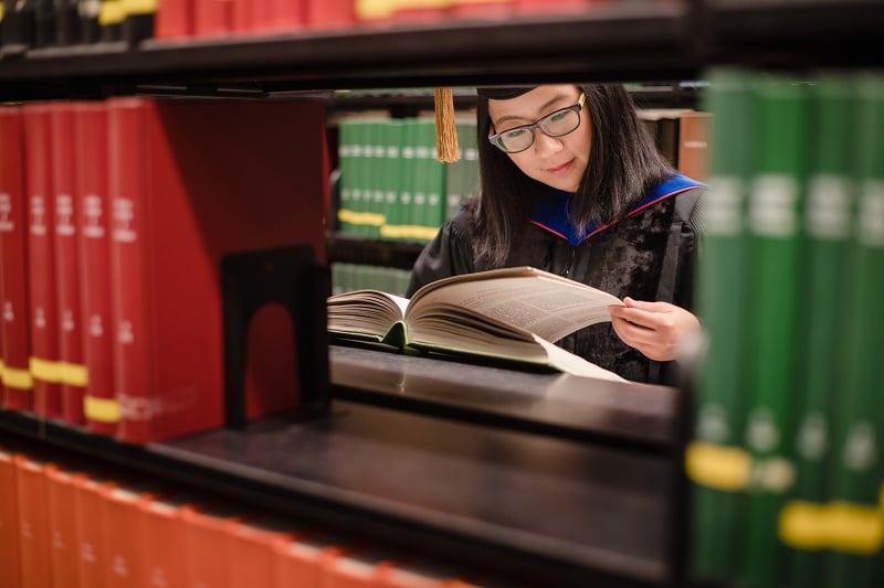 smu-phd-student-reading-a-book-before-graduation