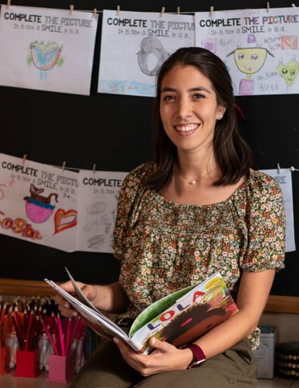 Angie Ringhauser M.Ed., Literacy Studies, Dual Language 2nd Grade Teacher holding a book