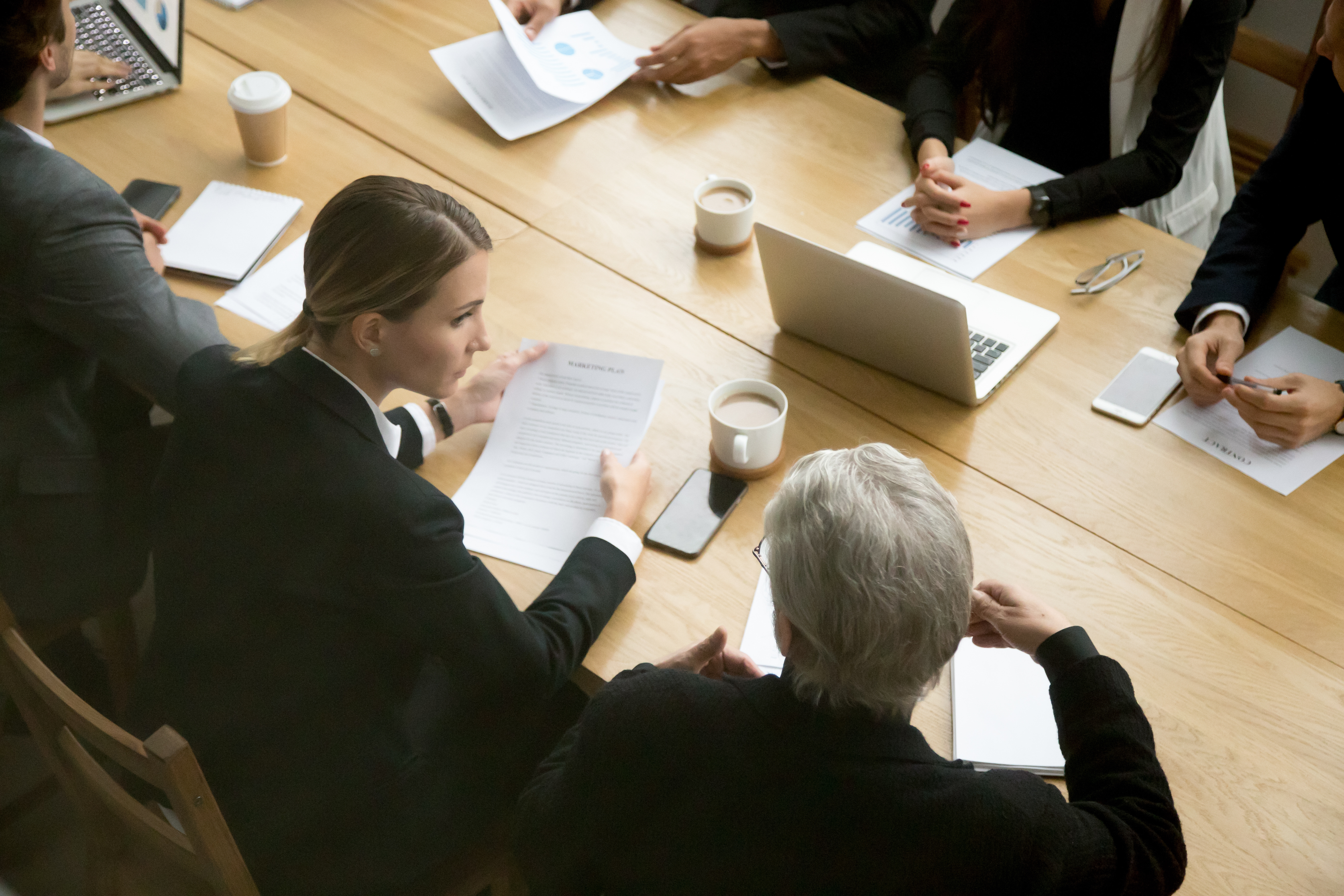 A group of business people sitting around a conference table in a mediation session.