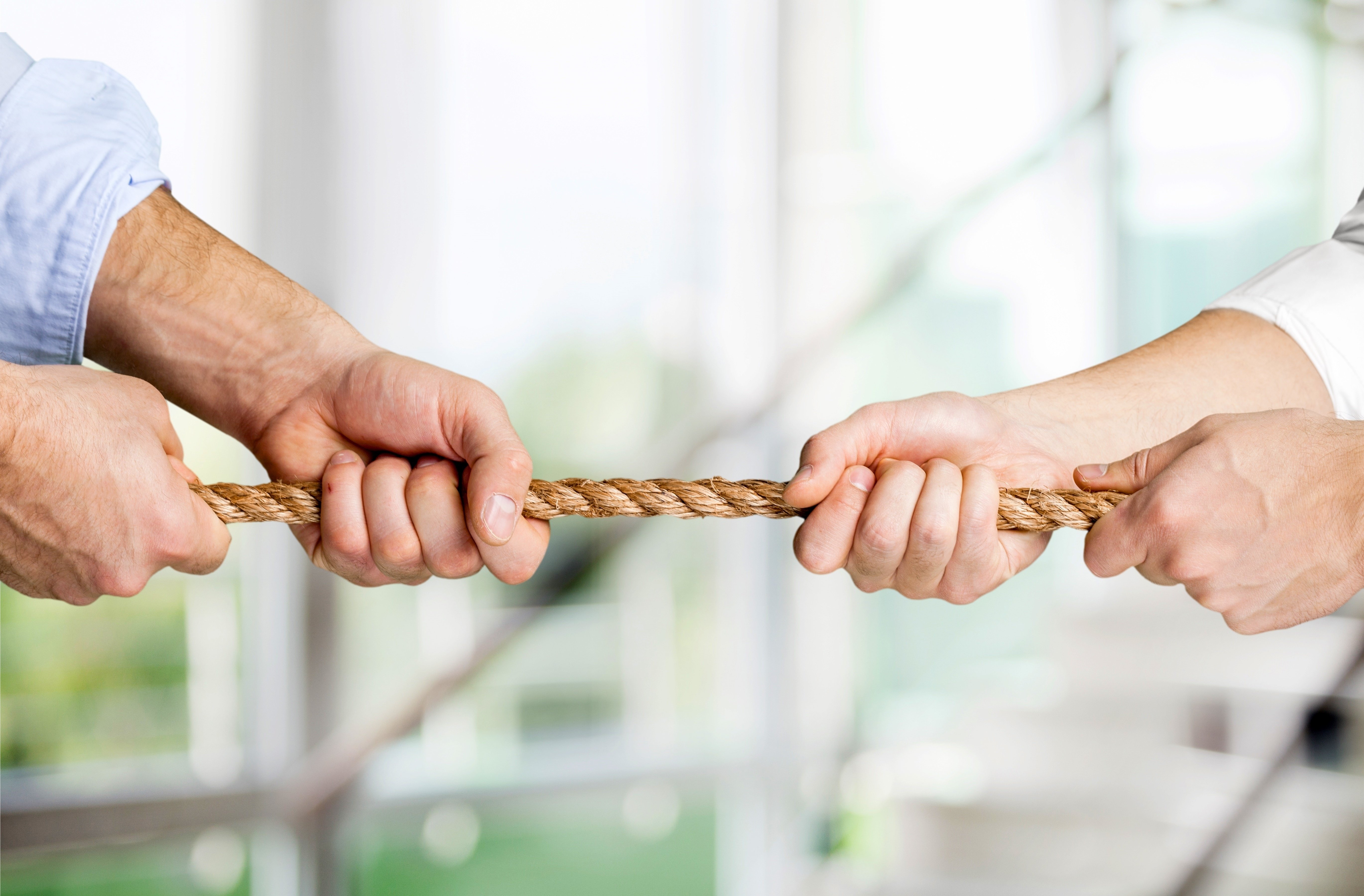 tug war, two businessman pulling a rope in opposite directions isolated on white background