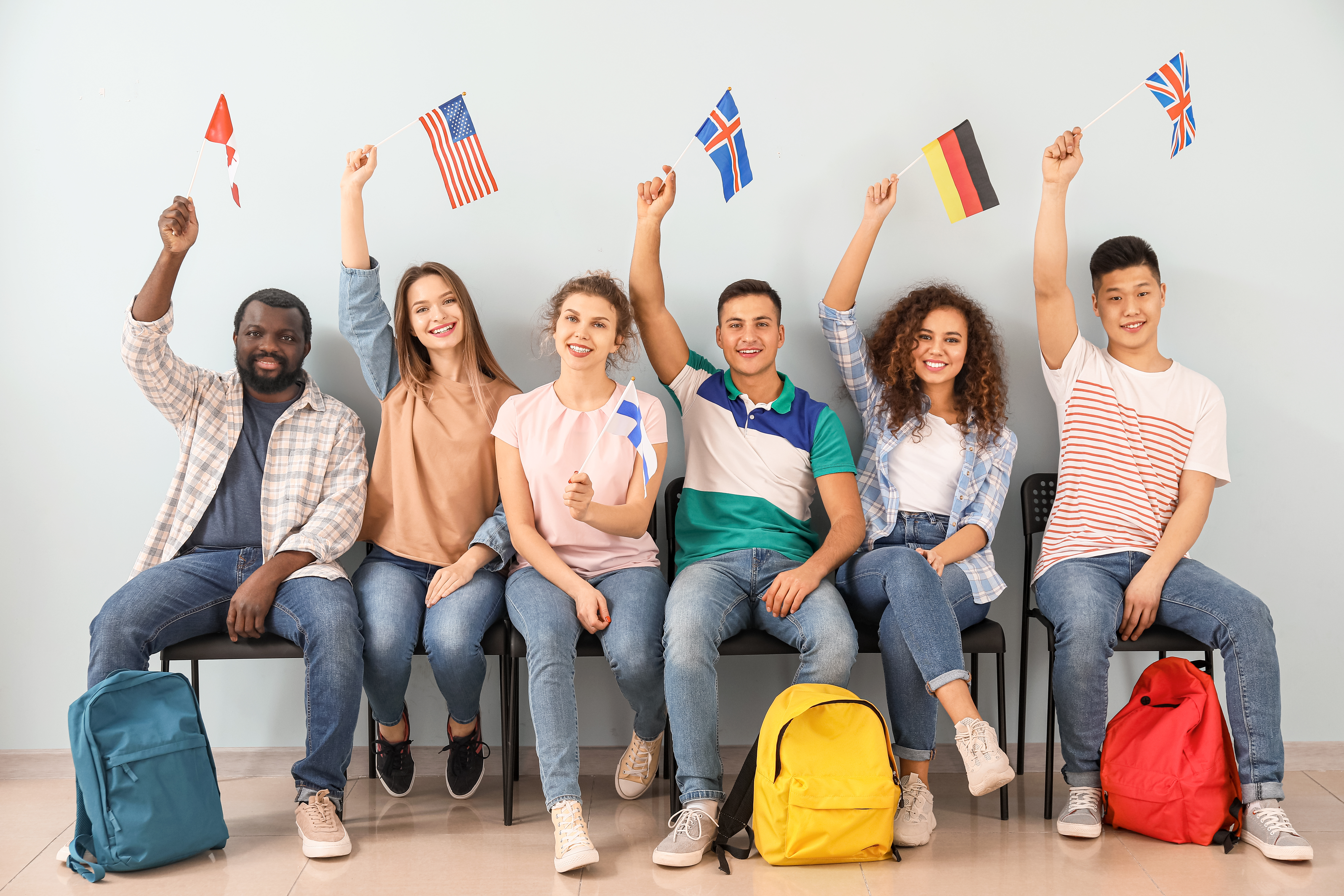 international students, sitting together and holding their country's flag