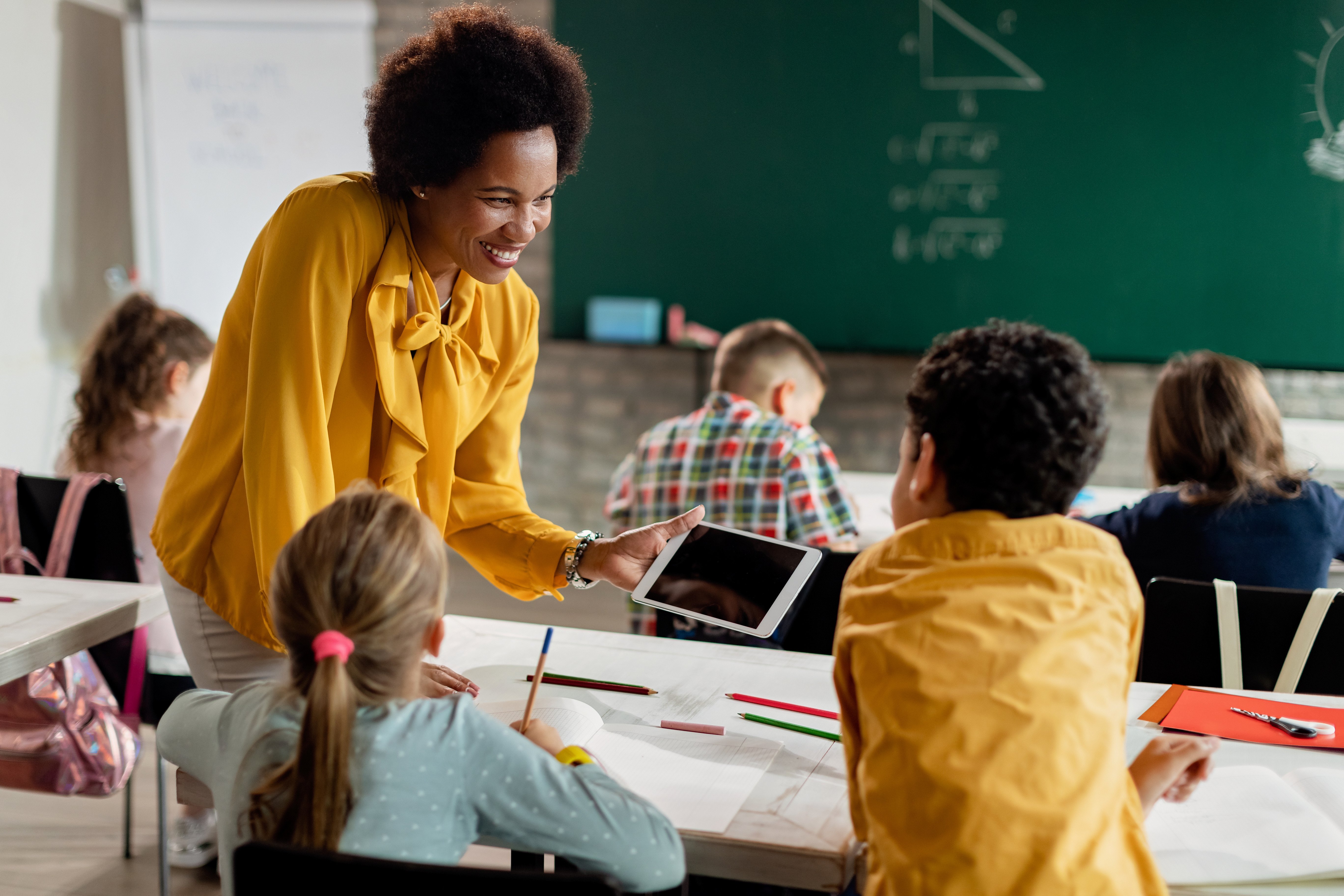 a women in a classroom teaching younger children