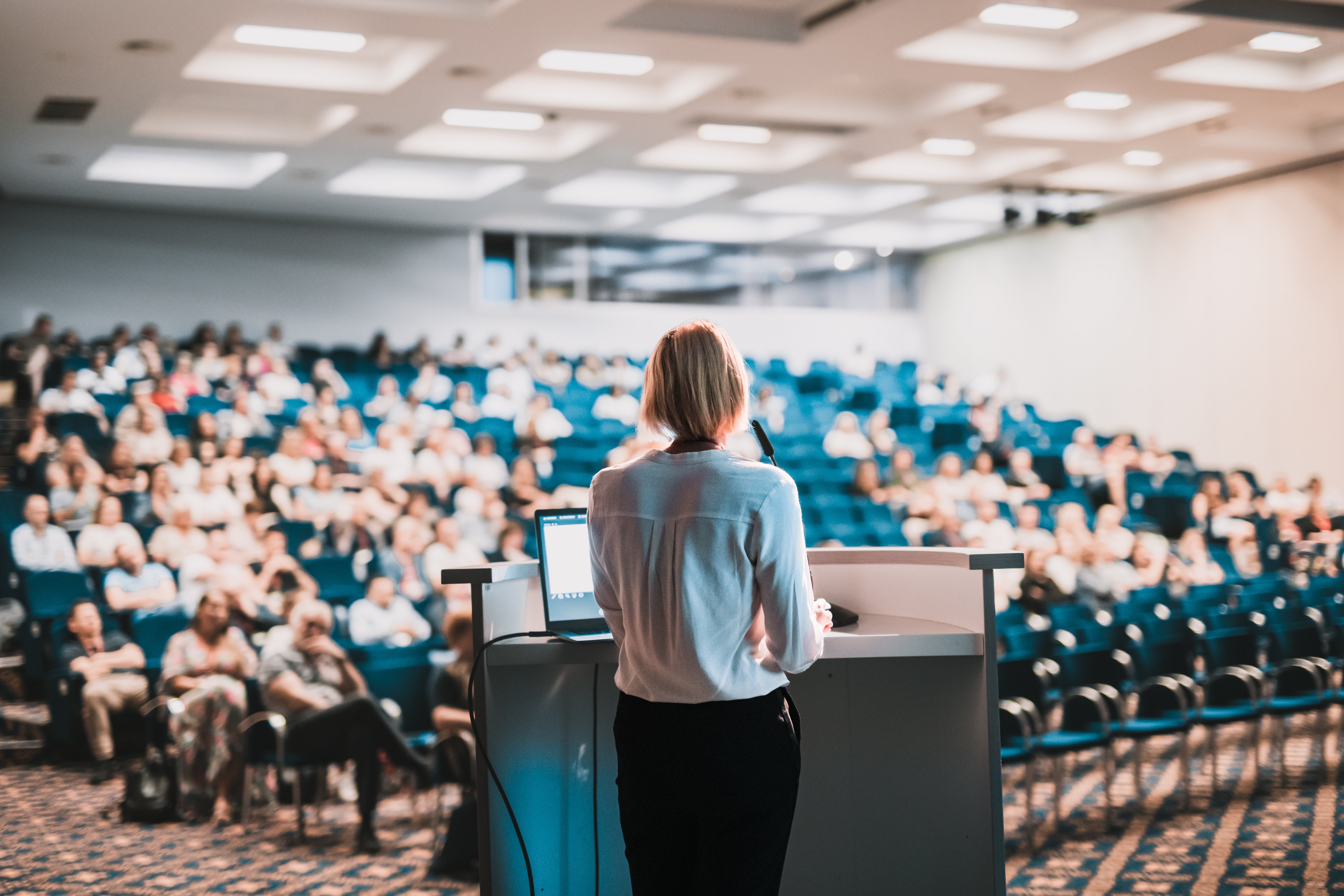 Female speaker giving a talk at a conference