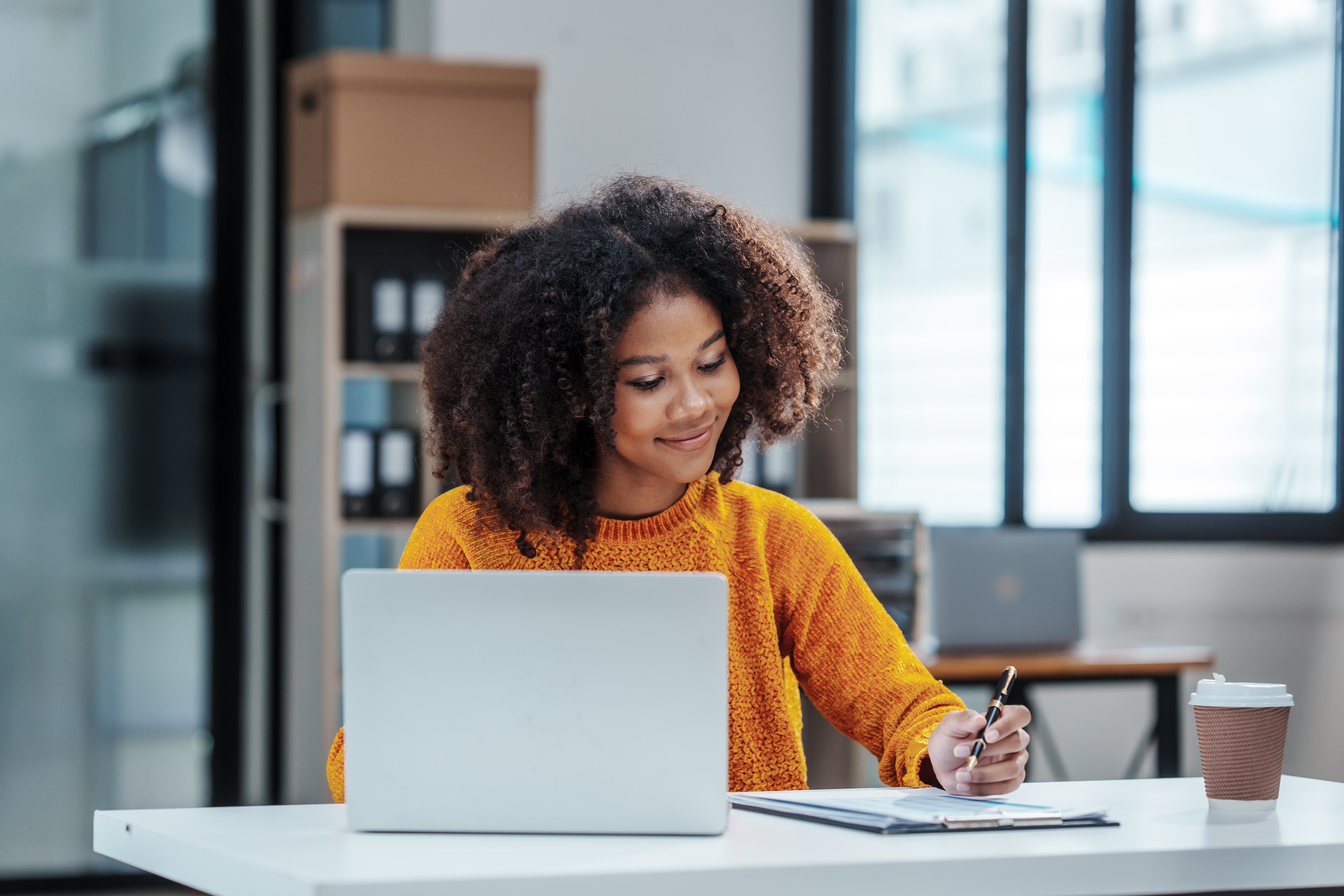 happy woman with a laptop taking notes