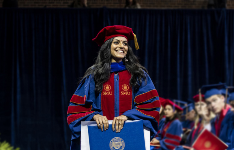 woman graduating from smu moody on stage in cap and gown 